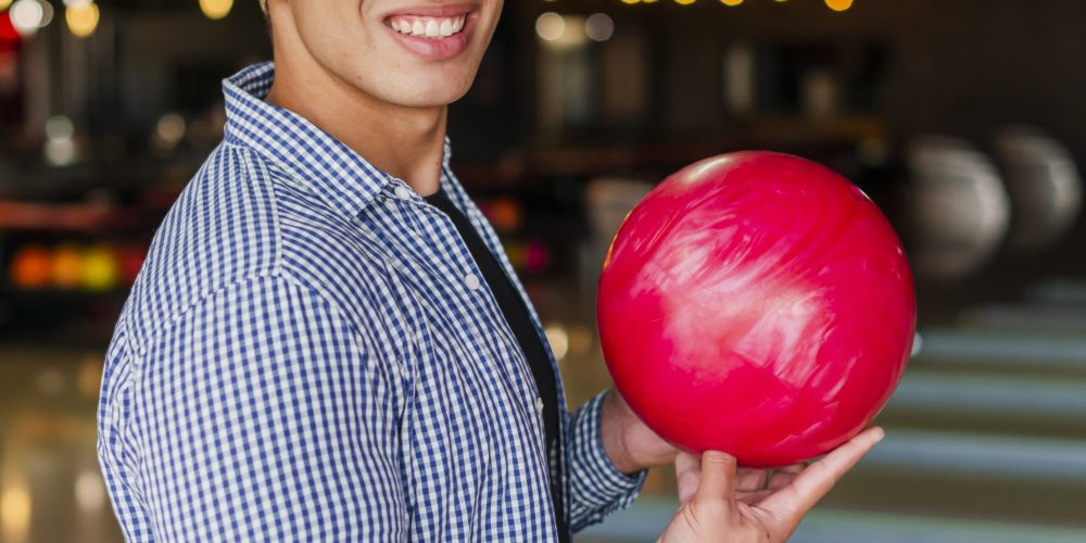 smiley-man-holding-red-bowling-ball-medium-shot